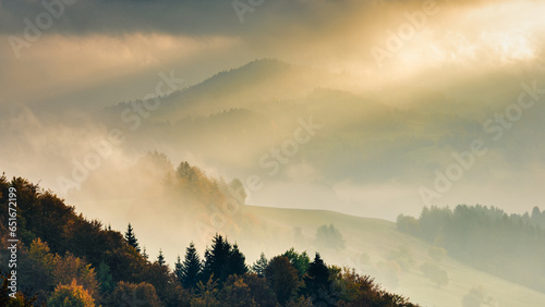 Autumn misty mountainous landscape with morning sun rays shining through the clouds. The Orava region of Slovakia, Europe.