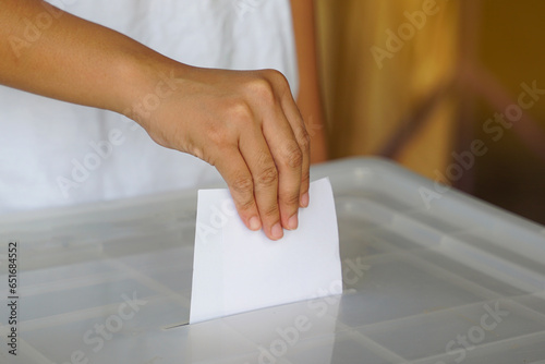 Hand drops a ballot into a box. Soft and selective focus. In the concept of voting system, voting, election, Members of the House of Representatives vote.