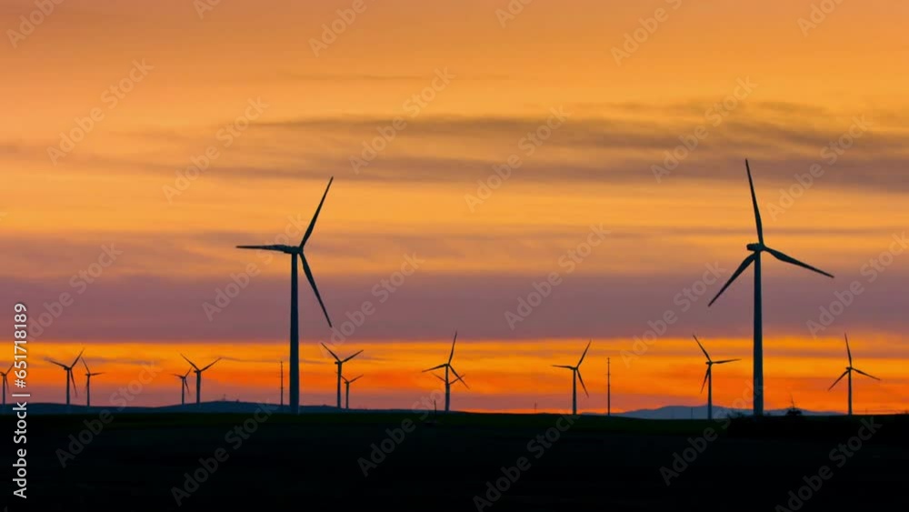 Wind Turbines on Wheat Field at Sunset with Grain Elevator - 4K Video Wind Turbines on Wheat Field at Sunset with Grain Elevator - 4K Video