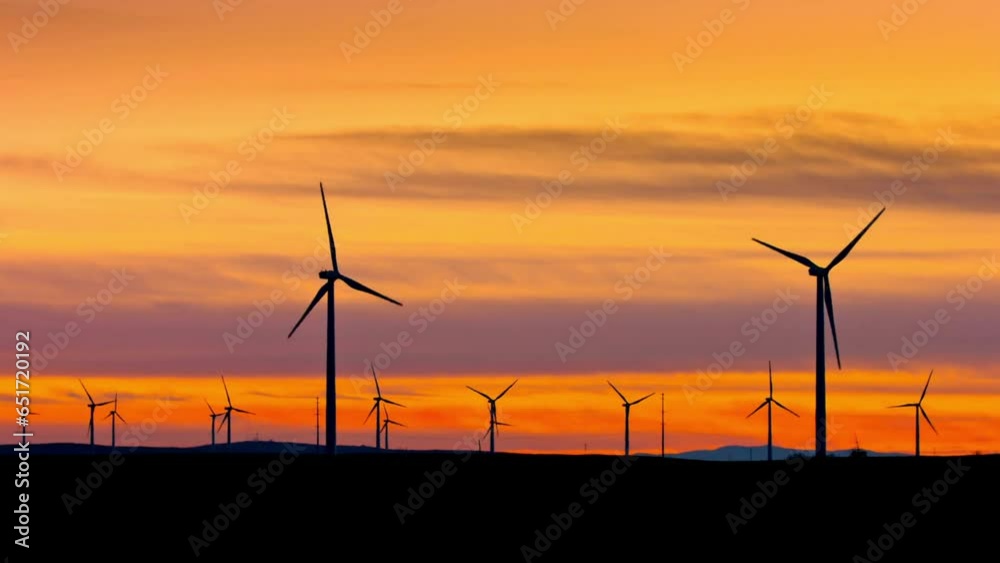 Wind Turbines on Wheat Field at Sunset with Grain Elevator - 4K Video