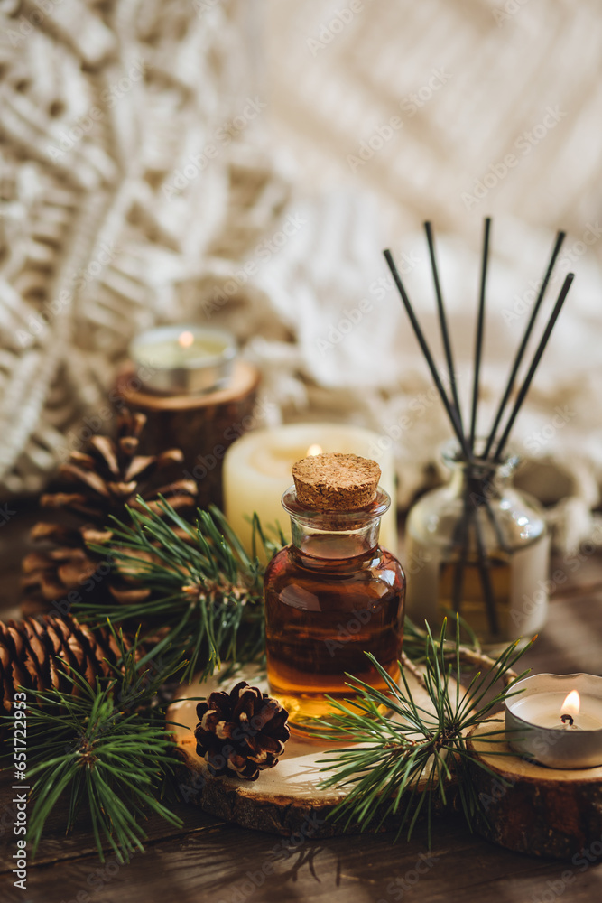 Aroma diffuser, burning candle, pine essential oil and perfume on wooden table. Cozy home decor, hygge and aromatherapy concept. Comfortable atmosphere, fresh smell Aroma diffuser, burning candle, pine essential oil and perfume on wooden table. Cozy home decor, hygge and aromatherapy concept. Comfortable atmosphere, fresh smell