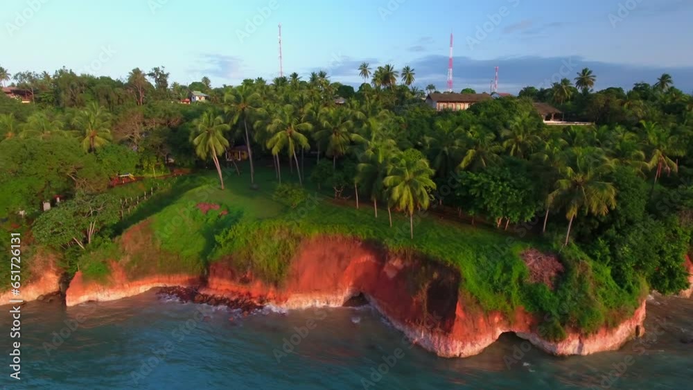 Aerial Panning Shot Of Trees And Plants Near Houses On Cliff, Drone Ascending Over Sea Against Sky At Sunset - Pipa Beach, Brazil
