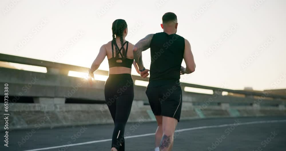 Couple, fitness and running in city for workout, outdoor exercise or training together in urban town. Rear view of active man and woman athlete or runners in sprint, cardio or sports marathon on road