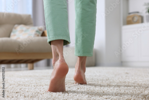 Woman walking on soft beige carpet at home, closeup