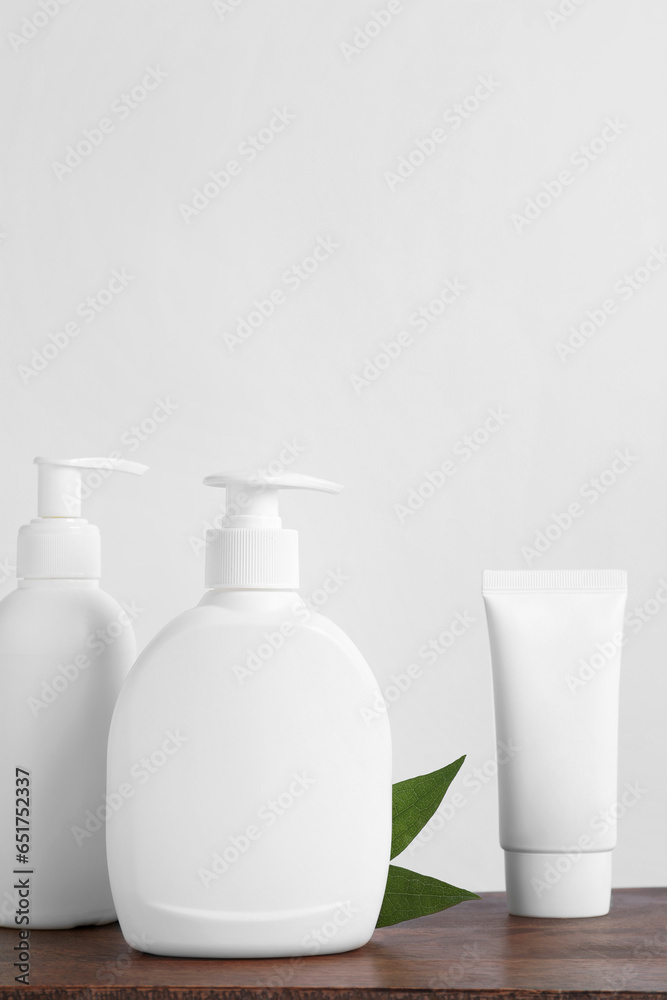 Bottles with different cosmetic products on wooden table Bottles with different cosmetic products on wooden table