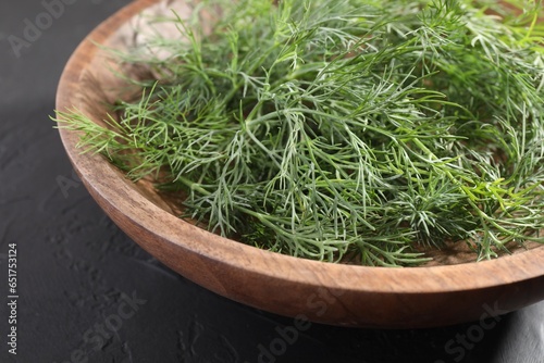 Bowl of fresh dill on grey textured table, closeup
