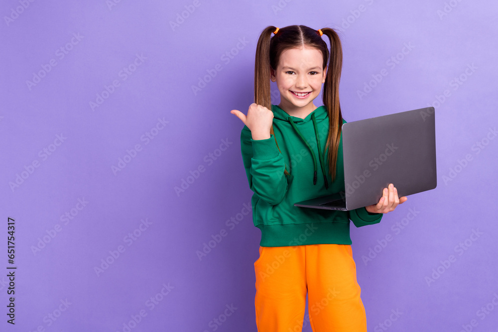 Photo of sweet pretty little girl dressed green hoody texting modern gadget thumb empty space isolated purple color background Photo of sweet pretty little girl dressed green hoody texting modern gadget thumb empty space isolated purple color background