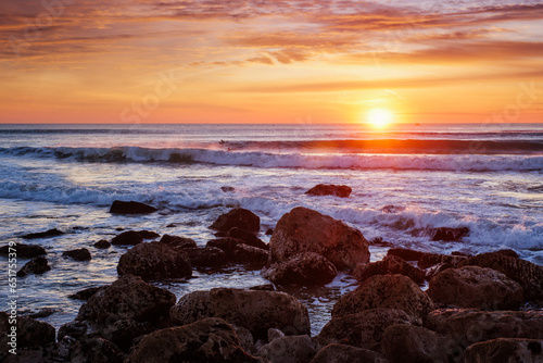Atlantic ocean sunset with waves and rocks at Costa da Caparica  Portugal