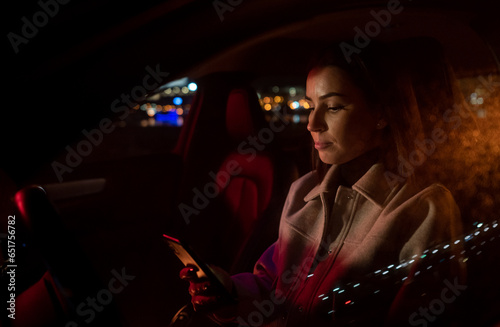 Beautiful businesswoman commuting from office in luxury car at night