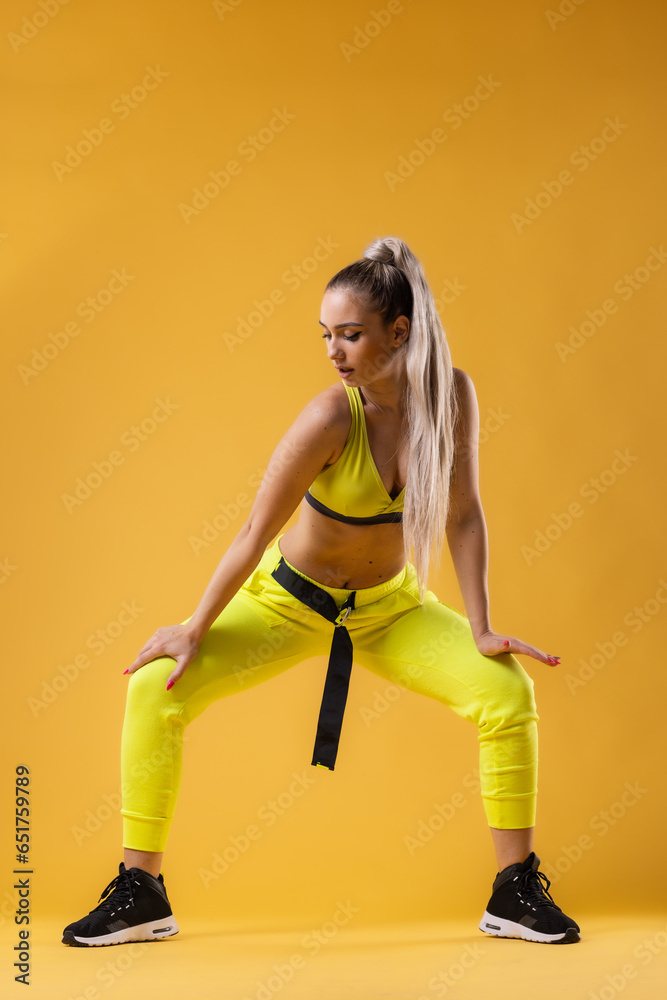 Beautiful girl in yellow outfit dancing zumba. Happy dance instructor against dark yellow or orange background. Beautiful girl in yellow outfit dancing zumba. Happy dance instructor against dark yellow or orange background.