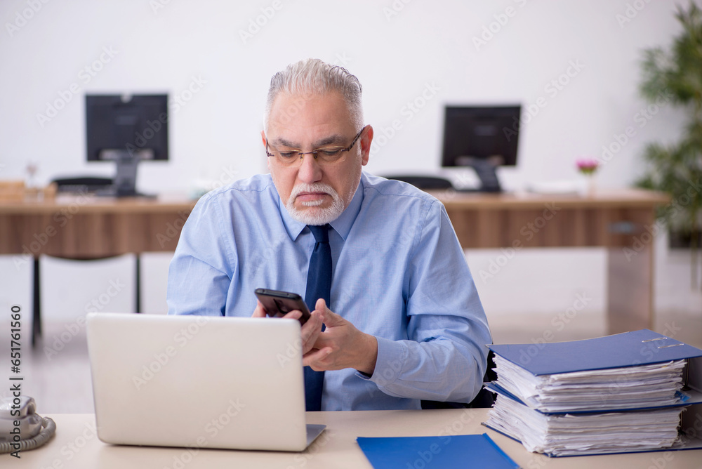 Old male employee working in the office Old male employee working in the office