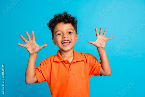 Photo of positive boy showing hands ten fingers isolated over blue color background