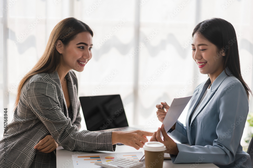 Businesswoman reading finance document with partner and discuss about new business project together Businesswoman reading finance document with partner and discuss about new business project together