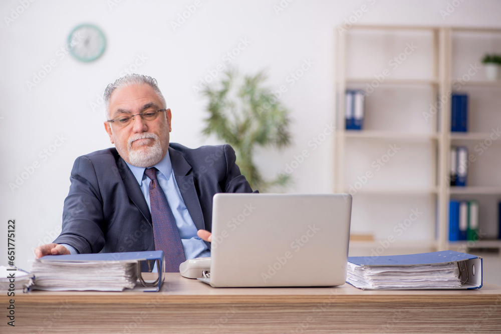 Old male employee working in the office Old male employee working in the office
