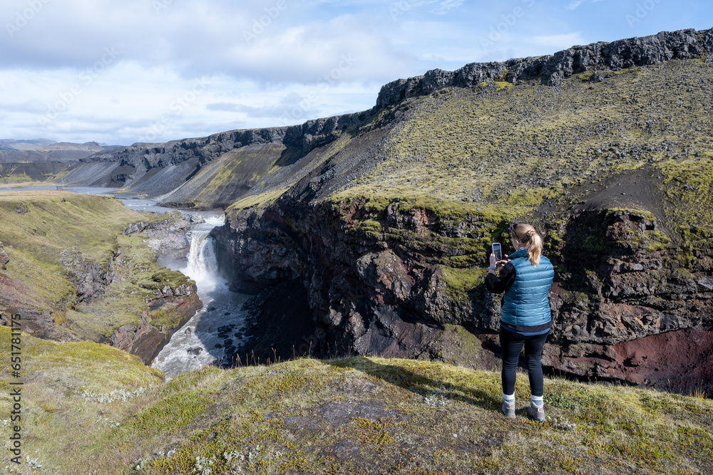 Woman enjoying view of Markarfjotsgljufur Canyon in Fjallabak Nature Reserve in Iceland. highlands on sunny autumn day.