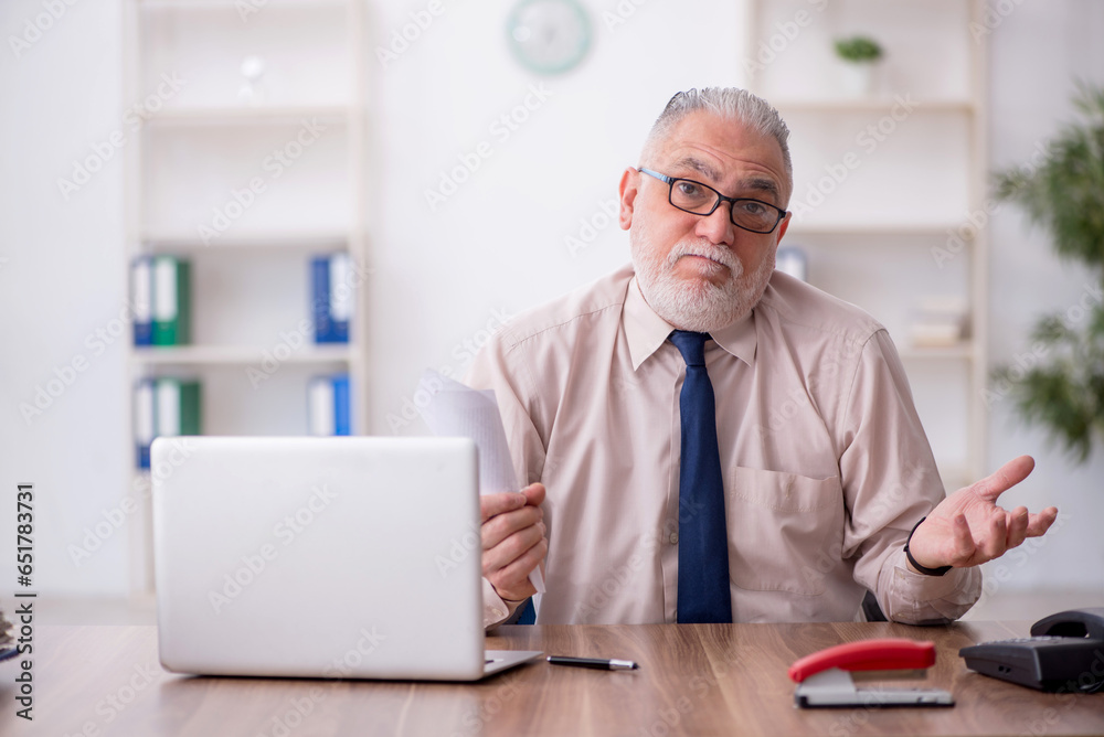 Old male employee working in the office Old male employee working in the office