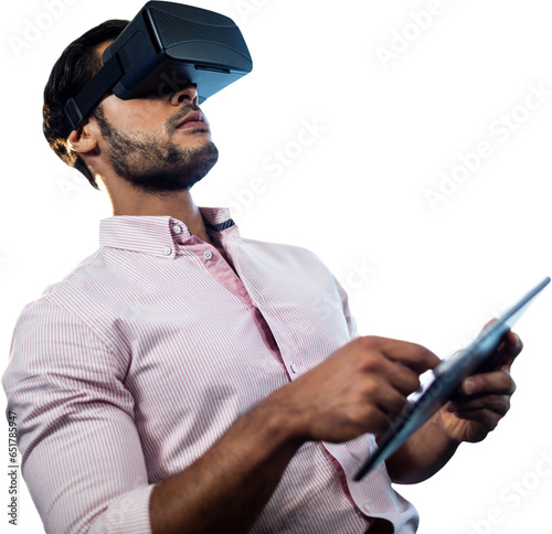 Digital png photo of caucasian man using vr headset and tablet on transparent background