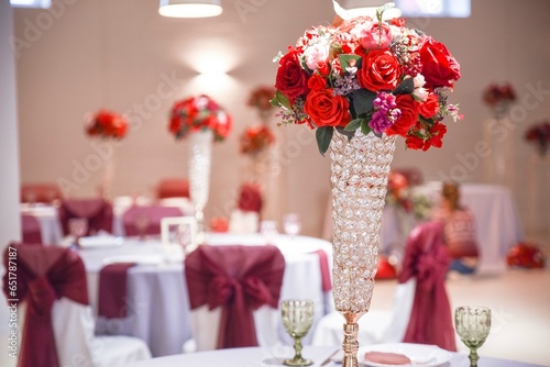 Tableau sur toile Festive table setting in banquet hall with red bouquets