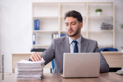 Young male employee and too much work in the office