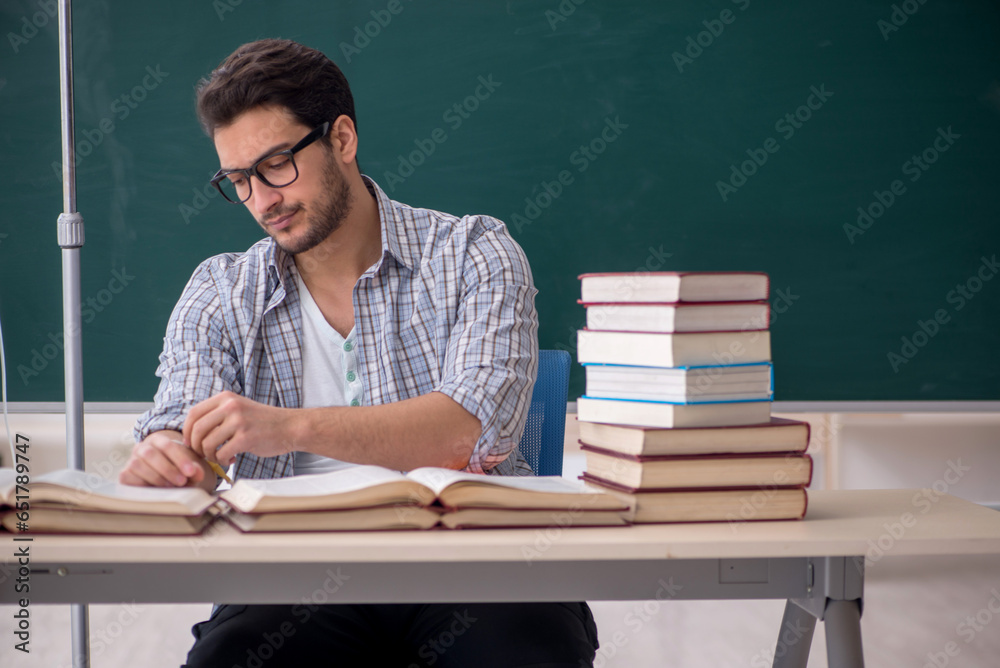Young male teacher suffering in the classroom Young male teacher suffering in the classroom