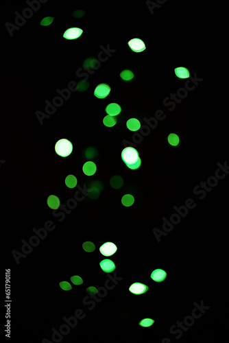 Green light, bokeh and glow on dark background isolated on a mockup space. Blur, black backdrop and defocused shine, sparkle or glitter at night for Christmas, holiday or party with magic color dots