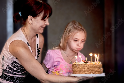 Girl trying to blow out candles on birthday cake