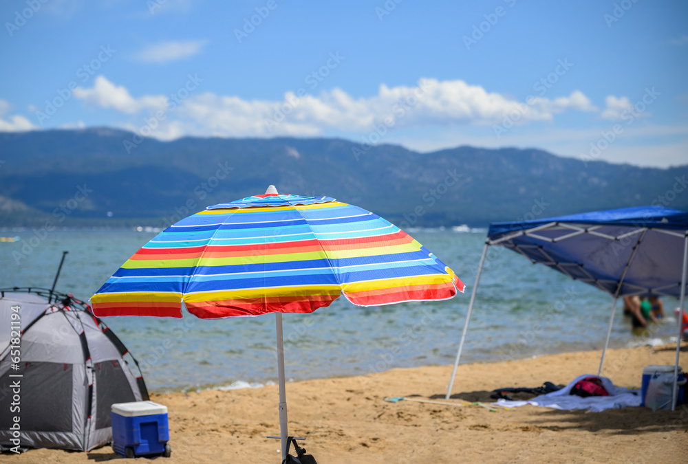 Beach umbrellas and tents at Pope Beach on a sunny summer day. South Lake Tahoe.