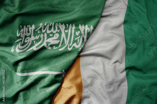 big waving realistic national colorful flag of saudi arabia and national flag of cote divoire .