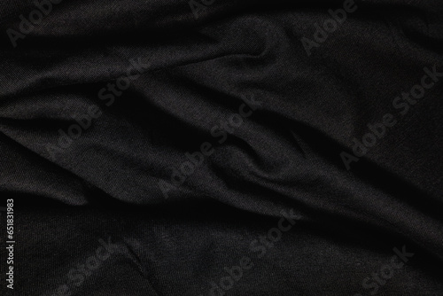 Dark wavy fabric background of black cloth texture
