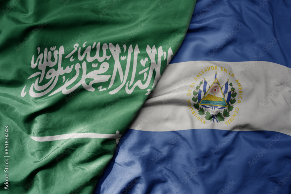 big waving realistic national colorful flag of saudi arabia and national flag of el salvador .