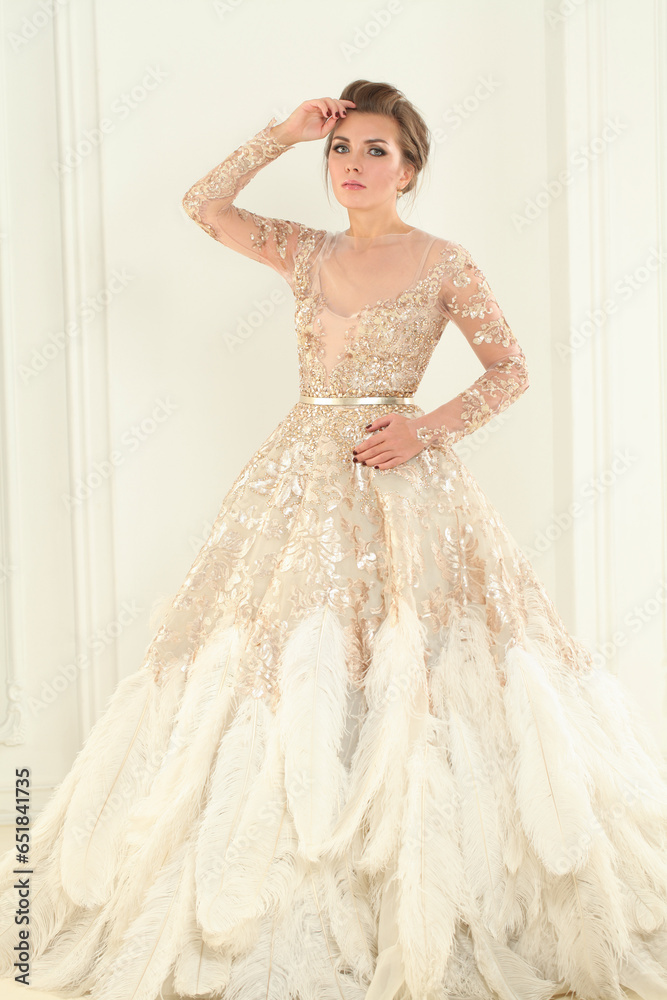 Beautiful woman in perfect shiny dress in white luxurious interior Beautiful woman in perfect shiny dress in white luxurious interior