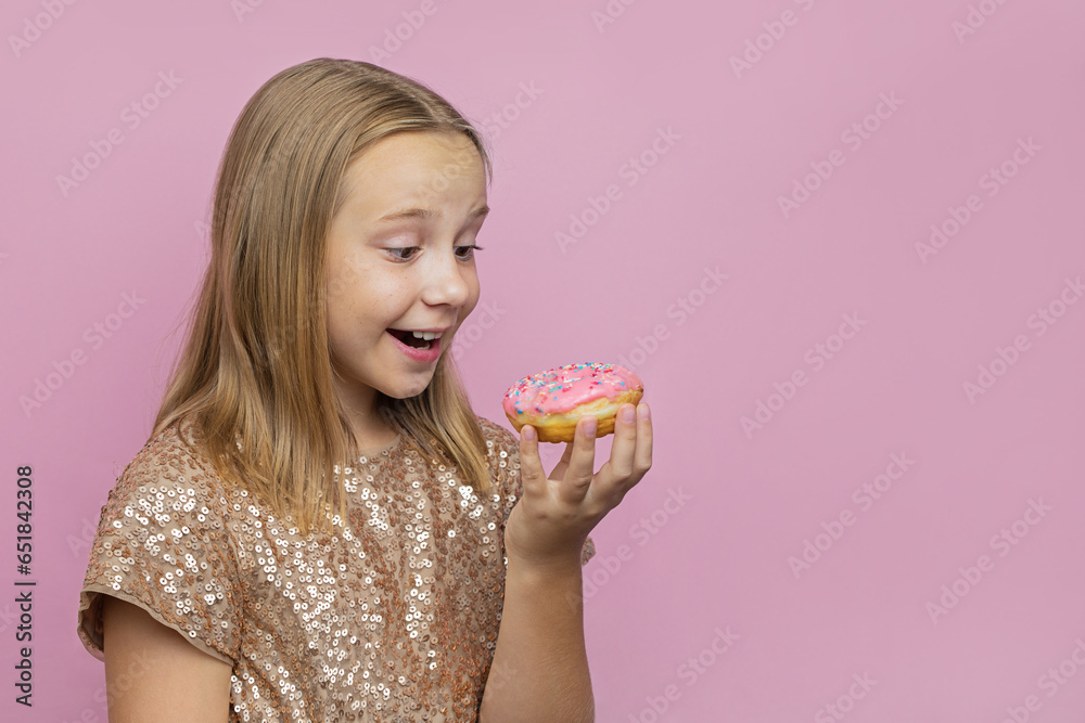 Adorable young girl holding donut on pink wall background. Child having fun with doughnut. Tasty food for kid. Funny time with sweet food Adorable young girl holding donut on pink wall background. Child having fun with doughnut. Tasty food for kid. Funny time with sweet food