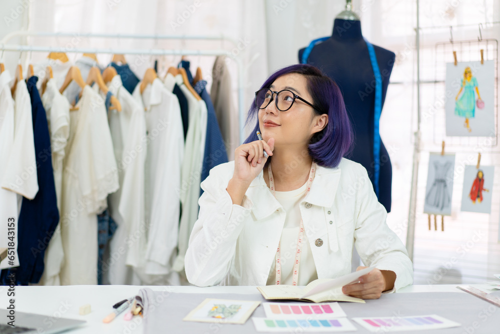 asian woman fashion stylist designers thinking of new suit collection, professional dressmaker design clothing for colleague partner, female freelance tailor working at dress shop small business owner
