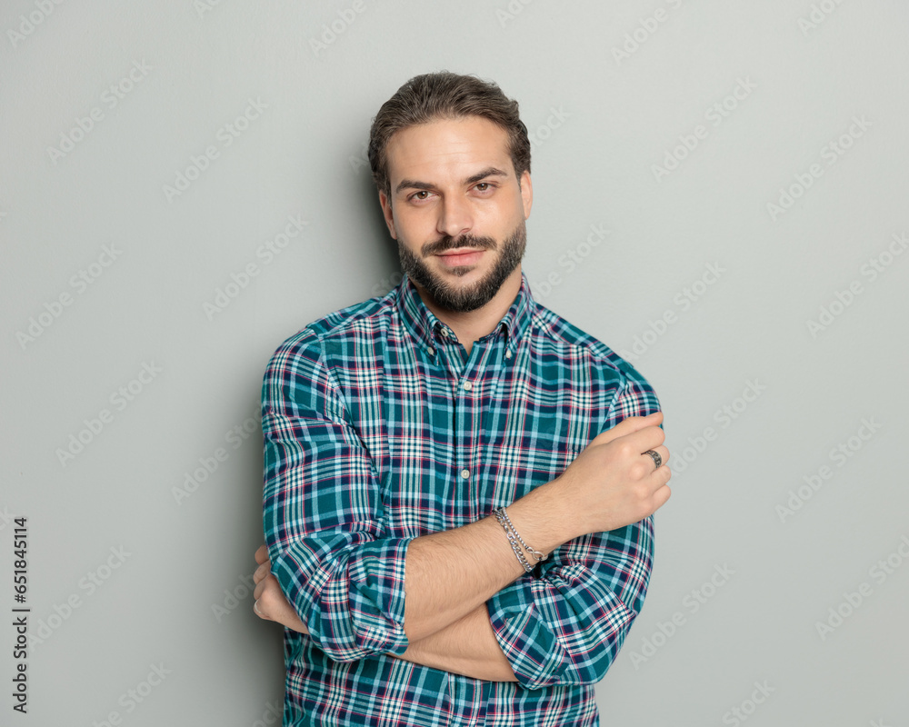 confident young man in casual shirt crossing arms and smiling confident young man in casual shirt crossing arms and smiling