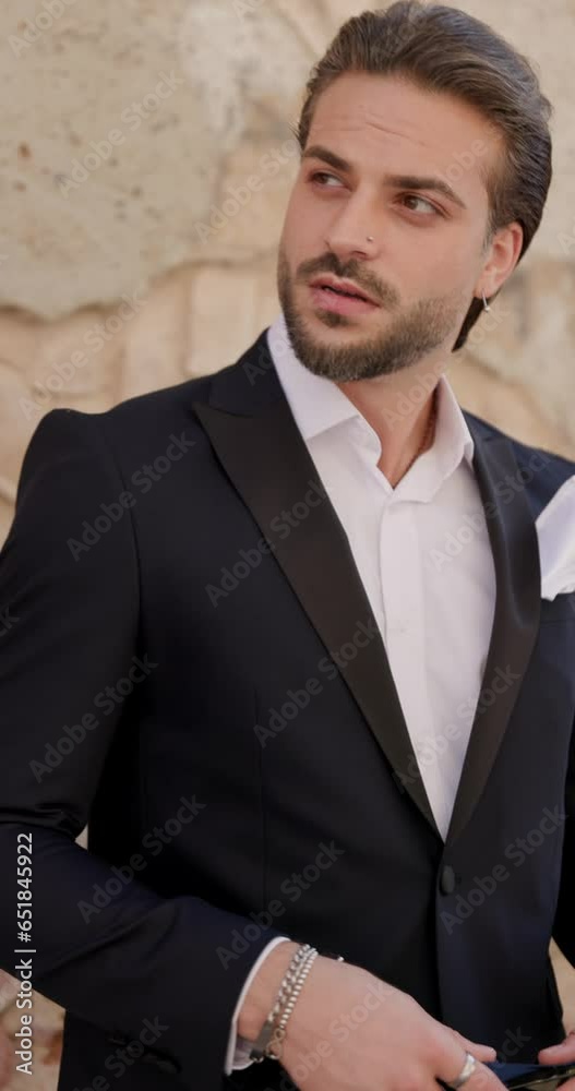 handsome young businessman with open collar shirt holding sunglasses looking to side, turning and walking away outdoor in a medieval city from Romania handsome young businessman with open collar shirt holding sunglasses looking to side, turning and walking away outdoor in a medieval city from Romania