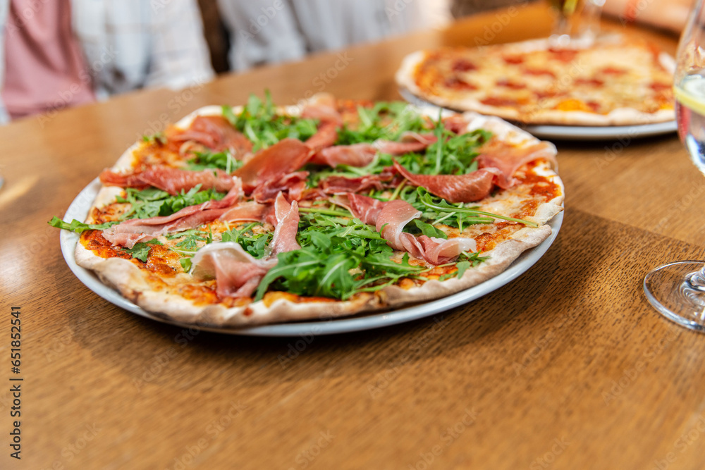 fast food, italian kitchen and eating concept - close up of pizza on wooden table