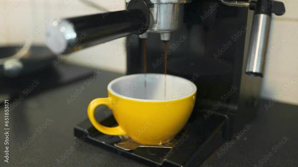 Coffee machine filling a cup with expresso. Yellow mug in automated coffeemaker machine. High quality FullHD footage Coffee machine filling a cup with expresso. Yellow mug in automated coffeemaker machine. High quality FullHD footage
