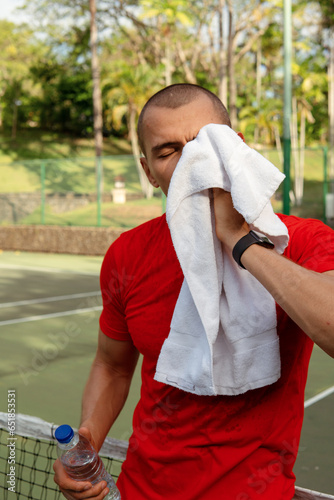 man wipes sweat with a towel