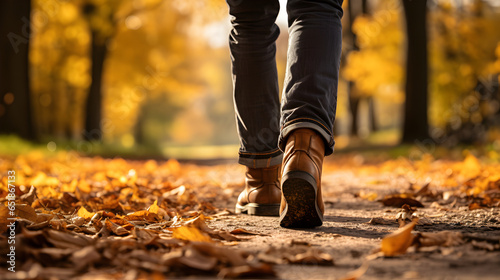 Feet of man walking on autumn park