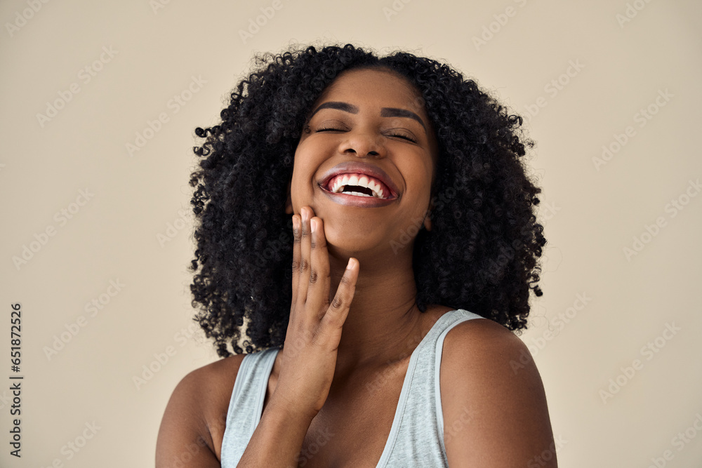 Happy confident young adult African American woman beauty female model, pretty 20s Black lady with curly hair beautiful face advertising skin care laughing isolated at beige background. Authentic shot - obrazy, fototapety, plakaty 