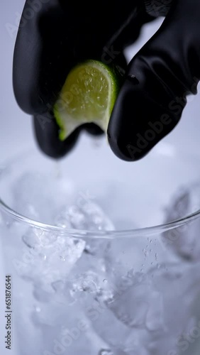 氷の入ったグラスにライムを絞る