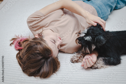 Portrait of a young beautiful woman and her black small dog at home