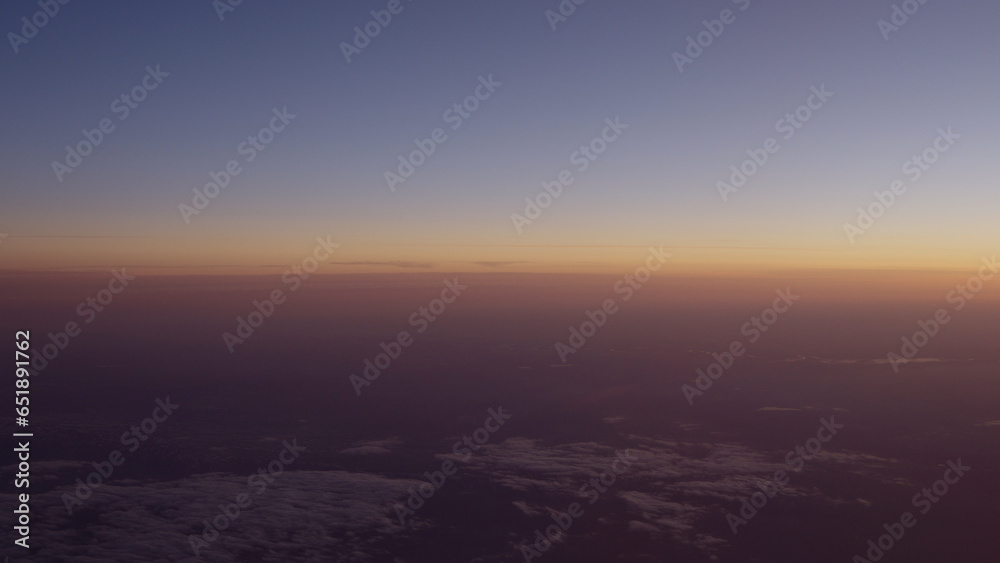 Airplane shot of flying over clouds in sunset Airplane shot of flying over clouds in sunset
