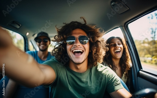 A young guy takes a selfie while traveling with friends by car
