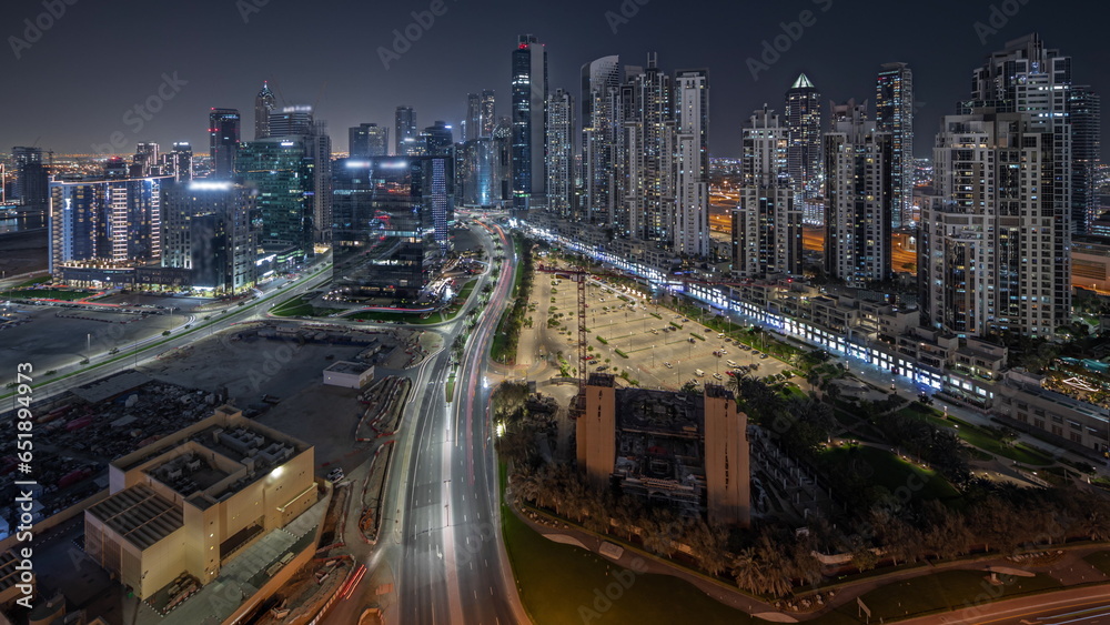 Panorama showing Bay Avenue with modern towers residential development in Business Bay aerial night, Dubai