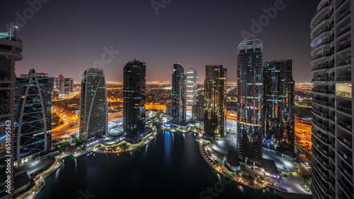 Tall residential buildings at JLT aerial all night, part of the Dubai multi commodities center mixed-use district.