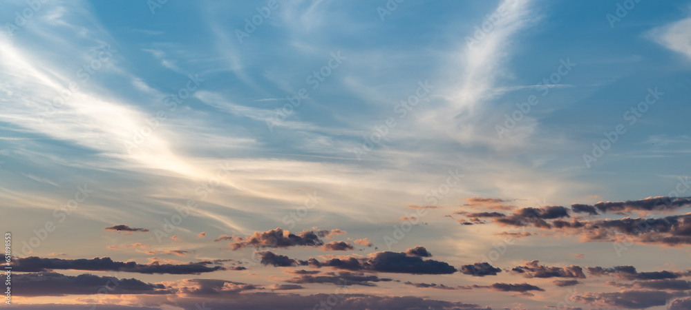 Frame with nice orange and yellow cirrus clouds in the sky at sunset