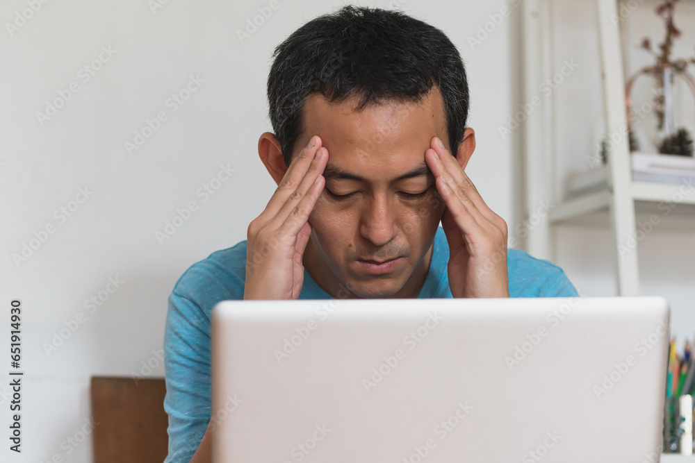 unhappy depressed young man sitting in living room feeling desperate a lonely and sad in mental health depression concept. unhappy depressed young man sitting in living room feeling desperate a lonely and sad in mental health depression concept.