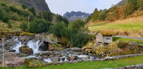 Natural landscape in the mountains. A charming little cottage on a stream in Norway. photo