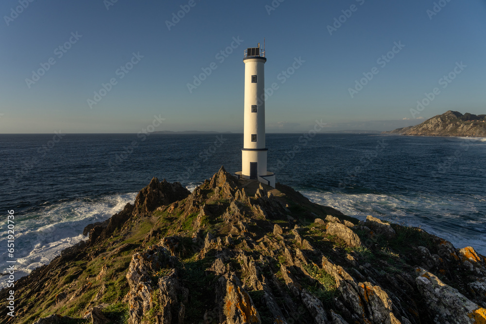 Cabo (cape) Home lighthouse on the cliffs at sunset in Rias Baixas zone in Galicia coast.
